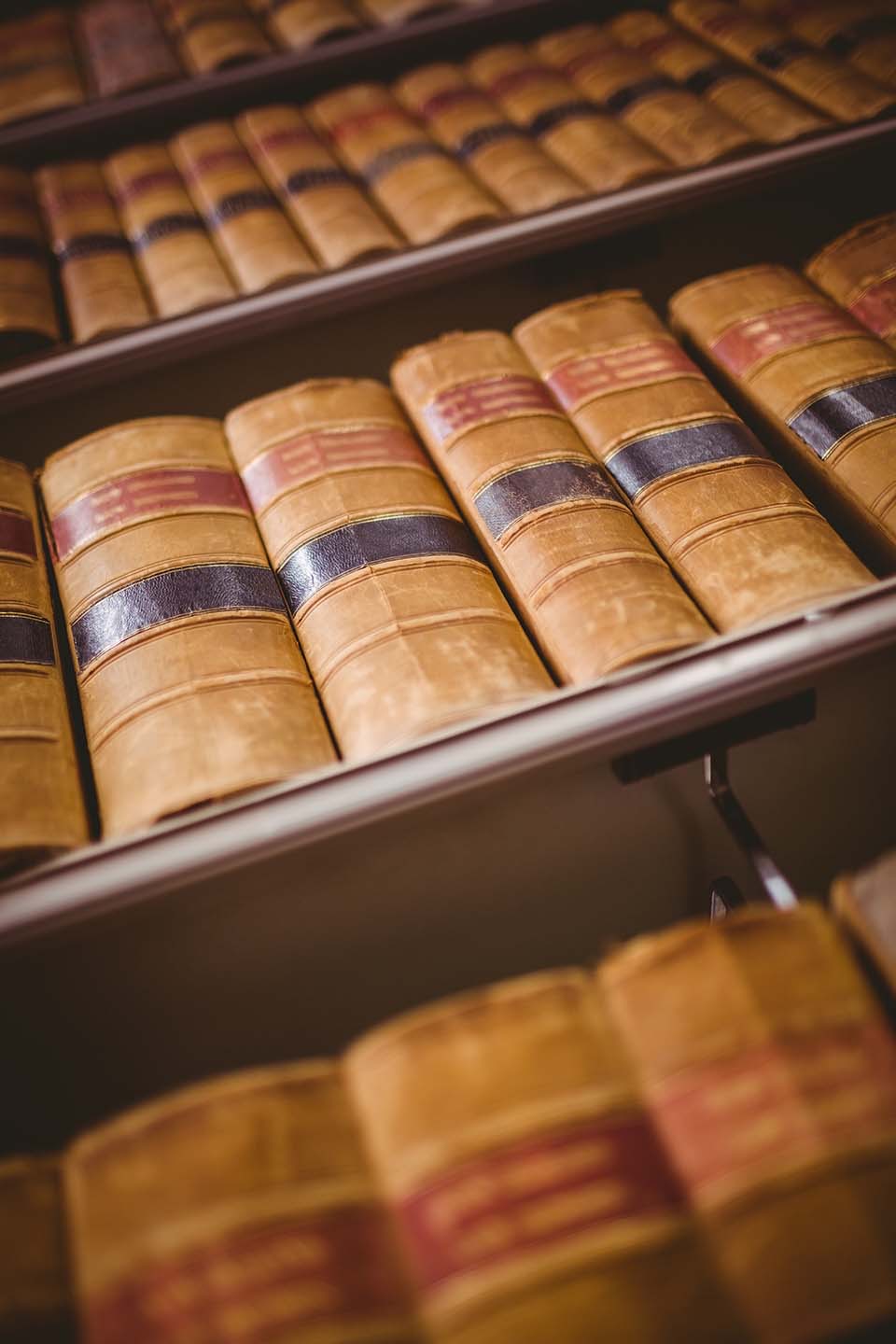 Rows of antique leather-bound books on library shelves